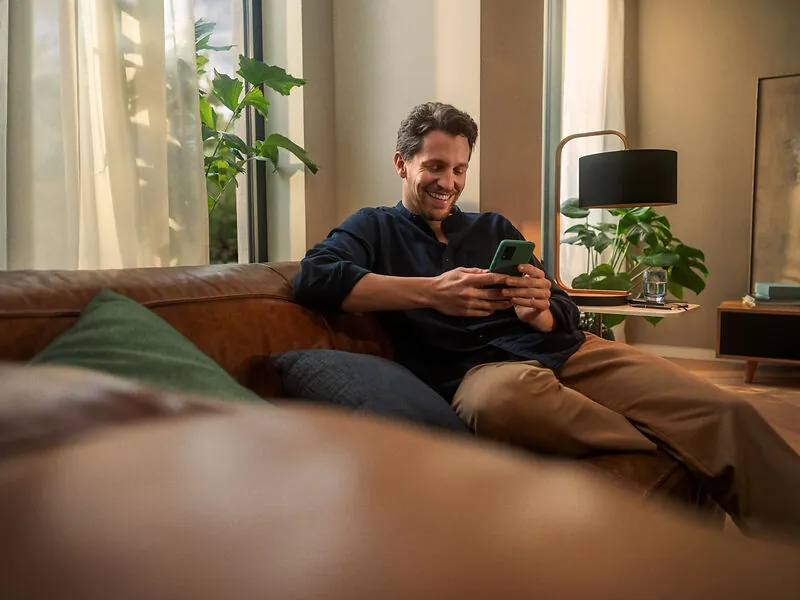 enercity Kunde entspannt mit Smartphone auf dem Sofa